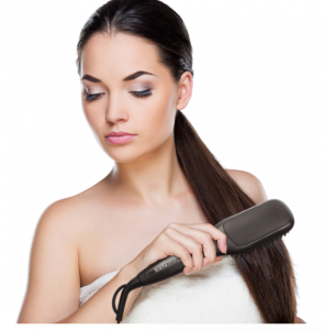 jeune femme passant une brosse lissante dans ses cheveux